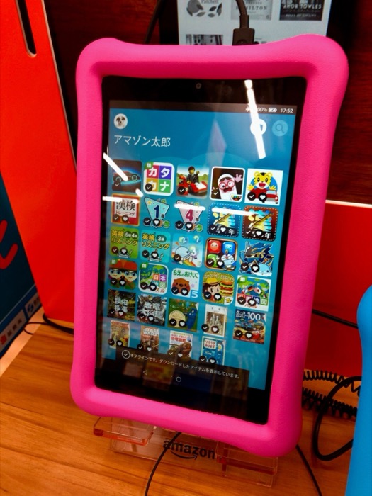 A color Fire HD Kids tablet in a protective bumper case, its screen showing a grid of bright children's app icons.